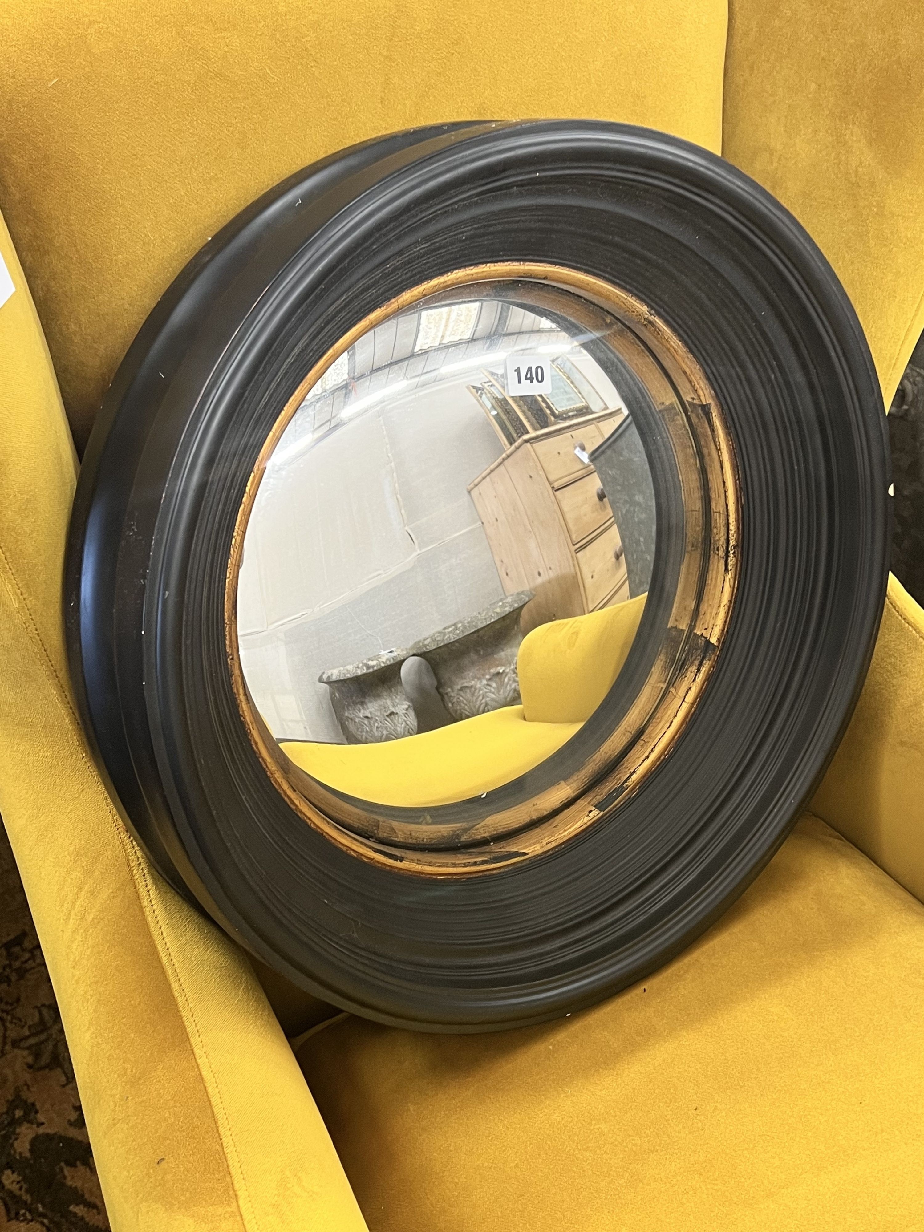 A contemporary black painted convex wall mirror with gilt slip, diameter 51cm